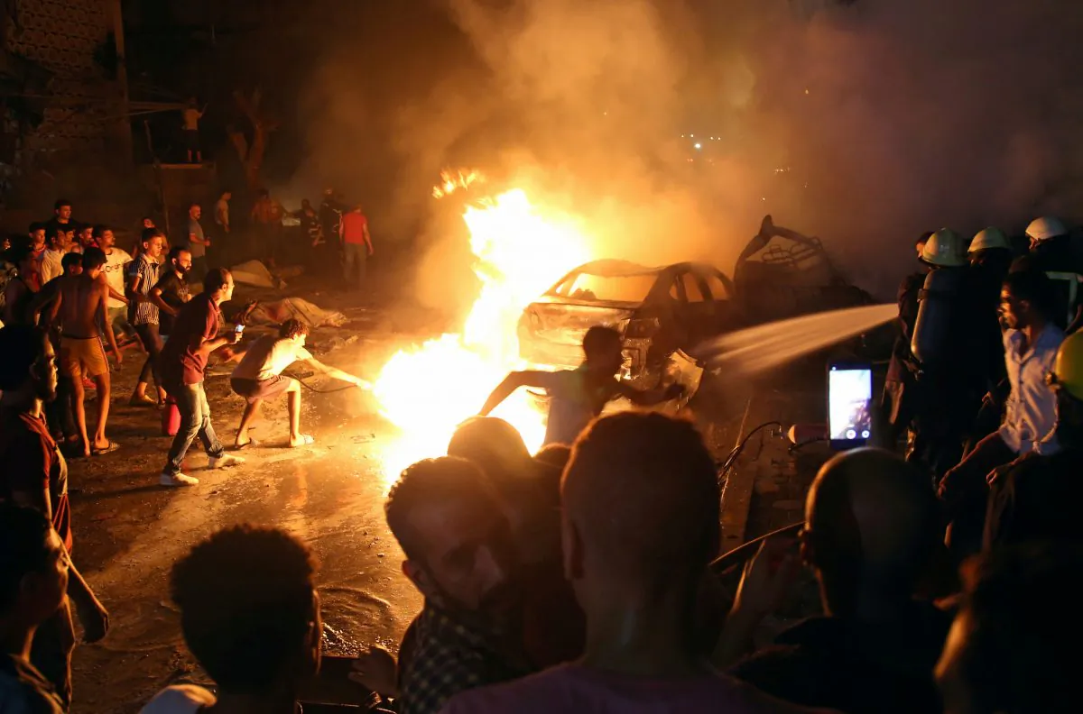 People extinguish a fire from a blast outside the National Cancer Institute, Cairo, Egypt on Aug. 4, 2019. (Shokry Hussien/Reuters)