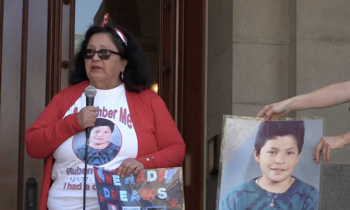 Angie Morfin with a picture of her son speaking in front of California State Capitol building on on June 21, 2019. (Nathan Su/Epoch Times)