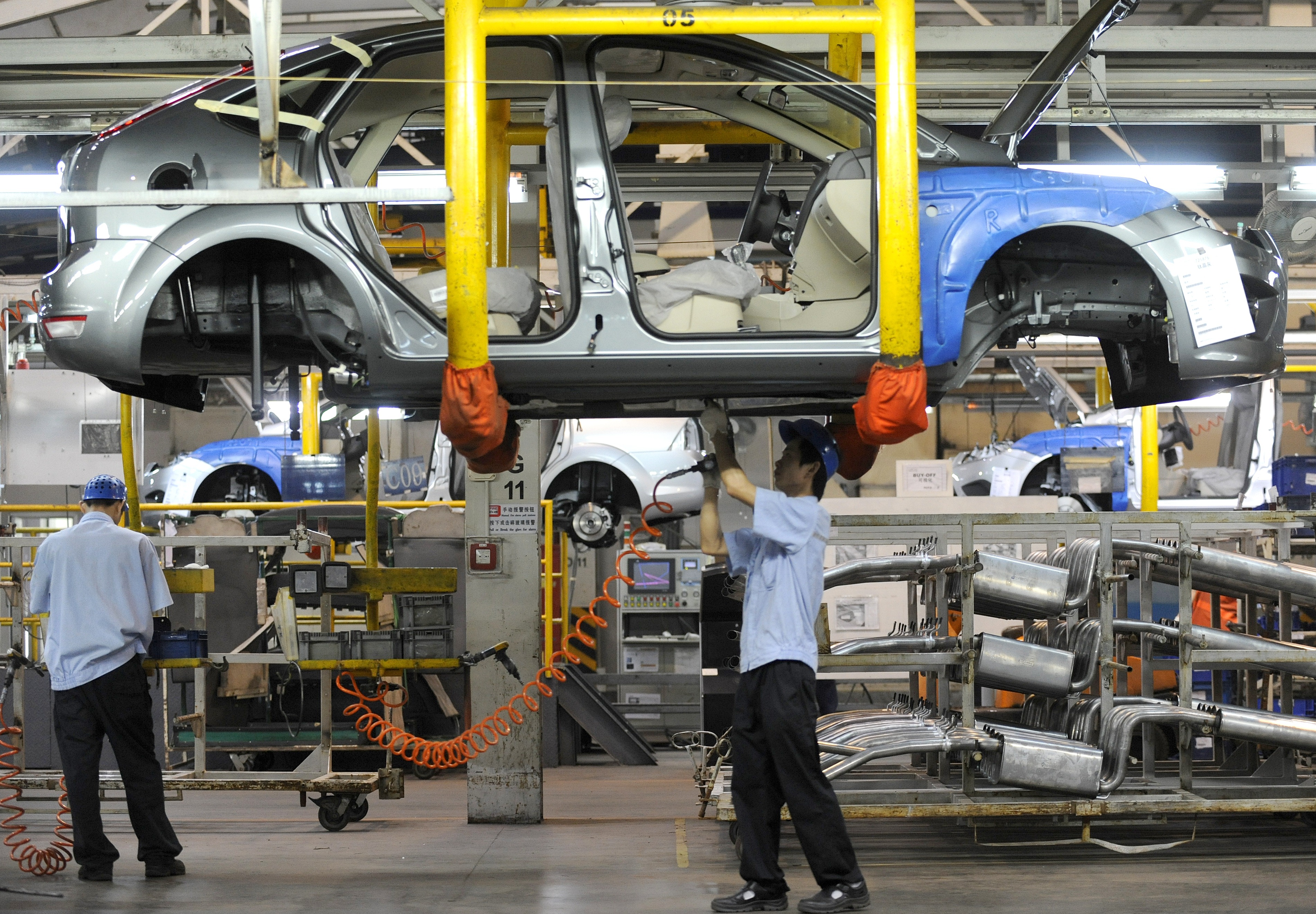 Workers on a vehicle assembly line at the Ford-Chang'an joint venture plant in Chongqing, China, on June 3, 2011. (LIU JIN/AFP/Getty Images)