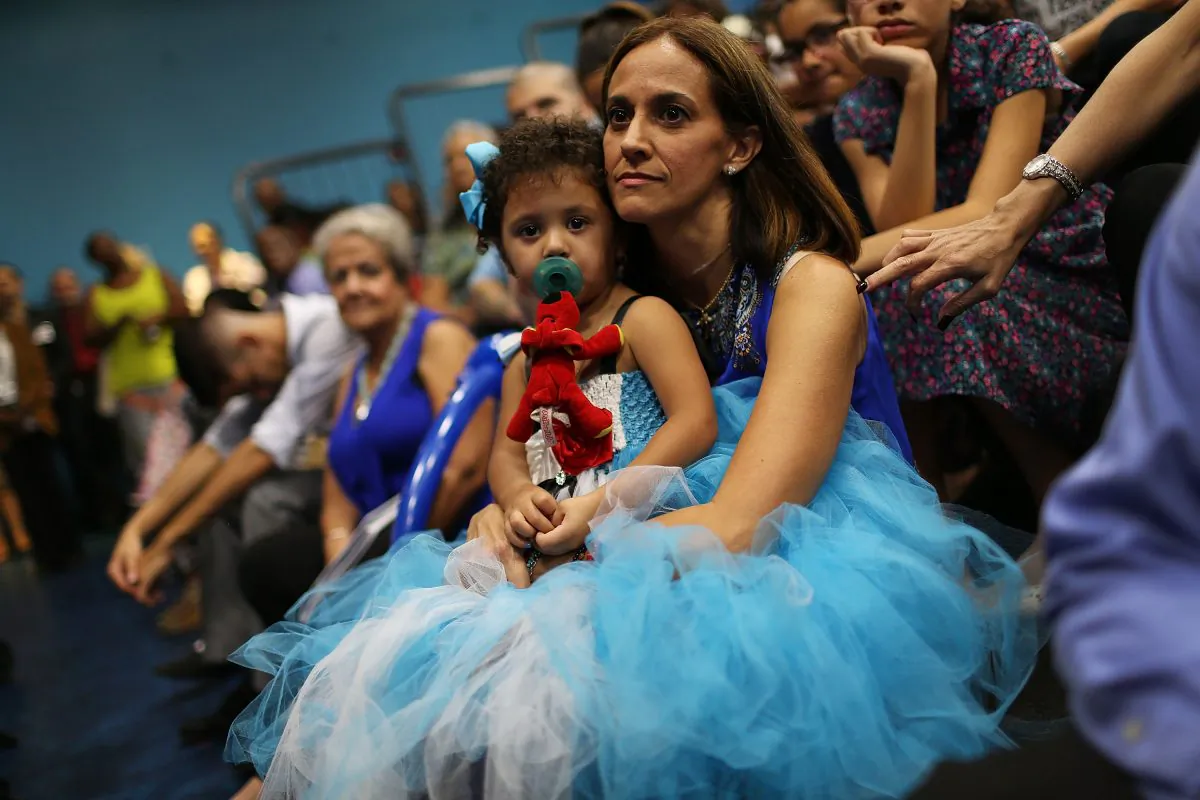 Grace Gonzalez sits with her adopted daughter Bella Gonzalez, 2, during an adoption ceremony on National Adoption Day in Miami, on Nov. 20, 2015.  (Joe Raedle/Getty Images)