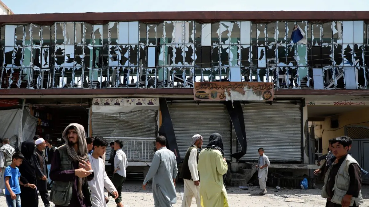 People walk in front of a building with broken windows at the site of a car bomb blast in Kabul, Afghanistan on Aug. 7, 2019. (Omar Sobhani/Reuters)
