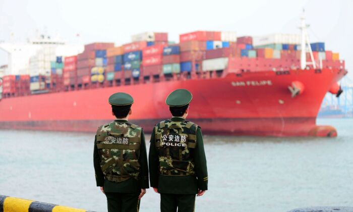 Chinese police officers watch a cargo ship at a port in Qingdao in China's eastern Shandong Province on March 8, 2018.
(AFP/Getty Images)