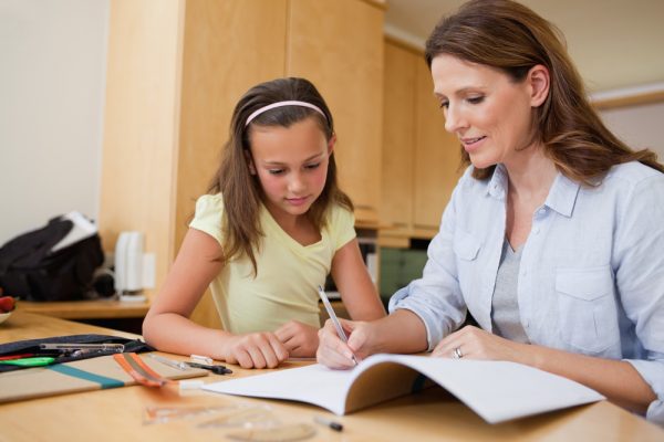 Mother helps her daughter with homework