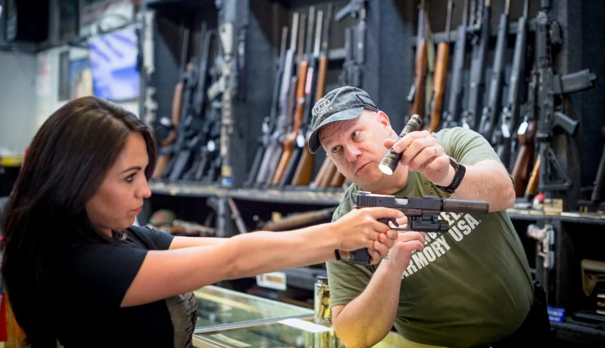 Edward Wilks, owner of Tradesmen Gun Store and Pawnshop, helps a customer with a firearm at his store in Rifle, Colo., on April 24, 2018. (EMILY KASK/AFP/Getty Images)