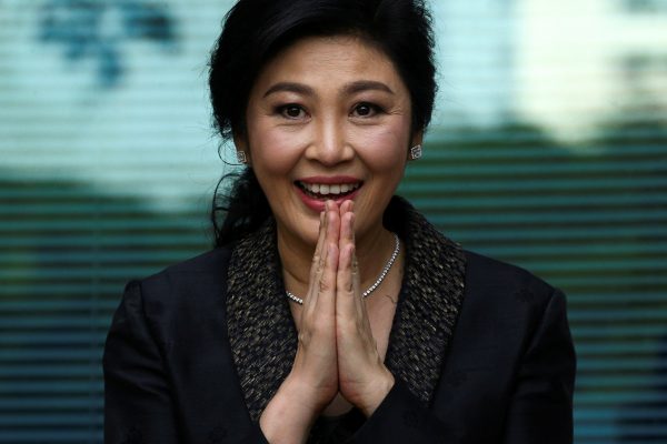 Thai prime minister Yingluck Shinawatra greets supporters as she arrives at the Supreme Court in Bangkok