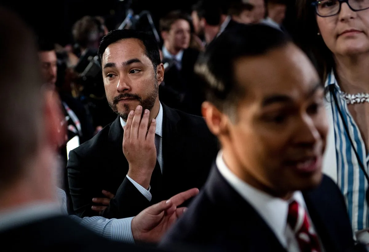 Rep. Joaquin Castro (D-Texas) (L), listens to his twin brother, former Obama administration official and current 2020 presidential candidate, speak to reporters after a debate in Detroit, Michigan, on July 31, 2019. (Brendan Smialowski/AFP/Getty Images)