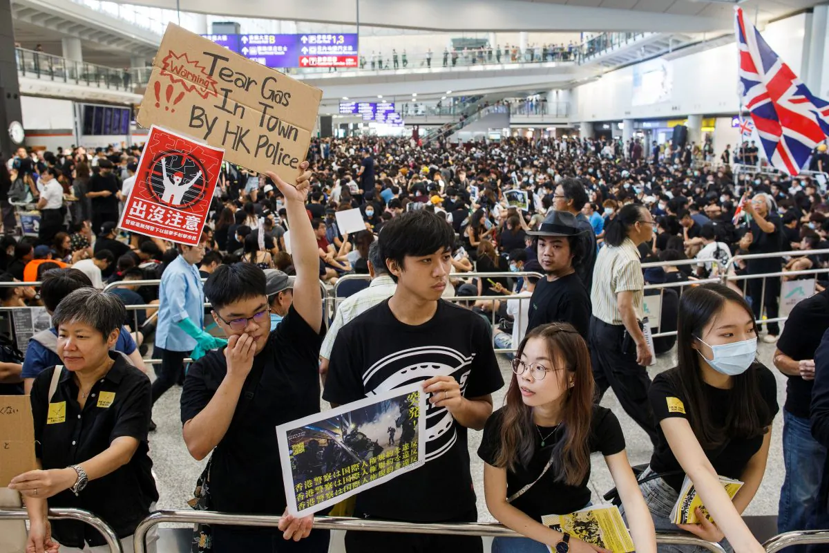 Anti-extradition bill protesters hold up placards for arriving travellers during a protest at the arrival hall of Hong Kong International Airport in Hong Kong, China on Aug. 9, 2019. (Thomas Peter/Reuters)