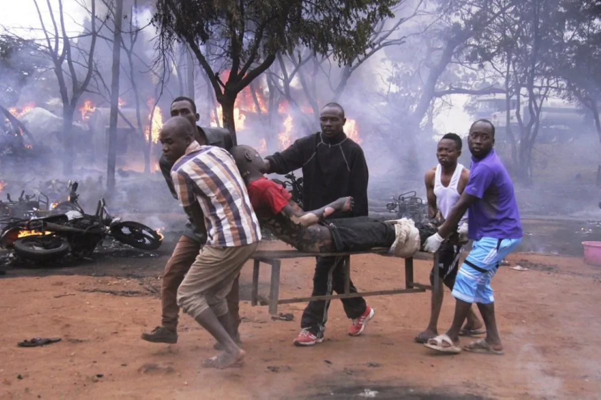 An injured man is carried from the scene as a patrol tanker burns in the background in Morogoro, Tanzania., on Aug. 10, 2019.
(AP Photo)