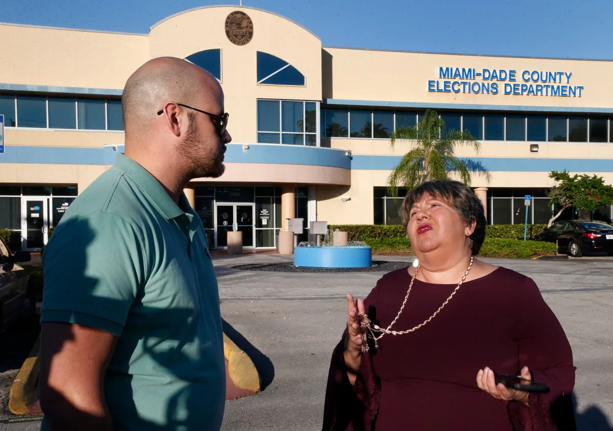 Convicted felons Daniel Torna and Yraida Guanipa share stories before heading in to the Miami-Dade County Elections Department to register to vote, in Miami, Fla., on Jan. 8, 2019. (RHONA WISE/AFP/Getty Images)