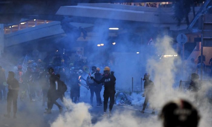 Protesters throw back tear gas canisters fired by the police in Tai Wai in the New Territories of Hong Kong on Aug. 10, 2019. (Manan Vatsyayana/AFP/Getty Images)