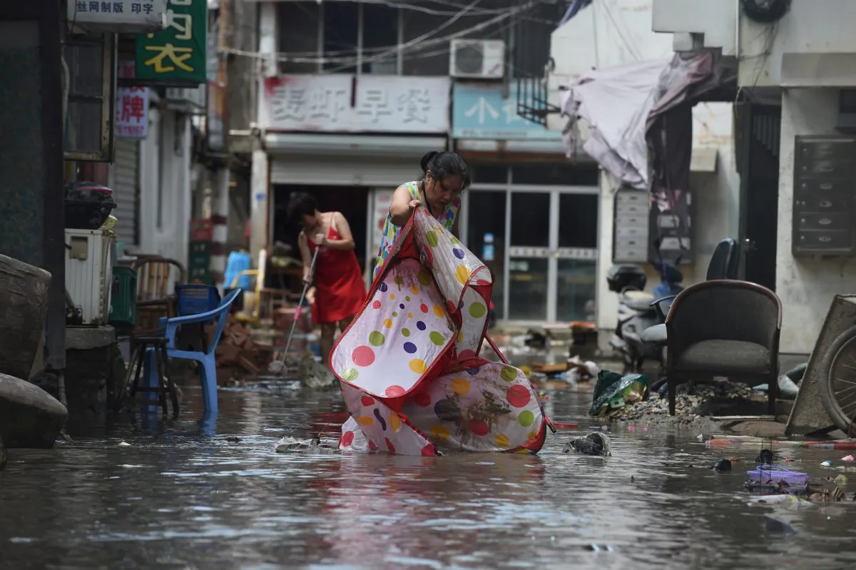 People clean a flooded street after typhoon Lekima hit Linhai City of Taizhou, Zhejiang Province, China on Aug. 11, 2019. (Reuters)