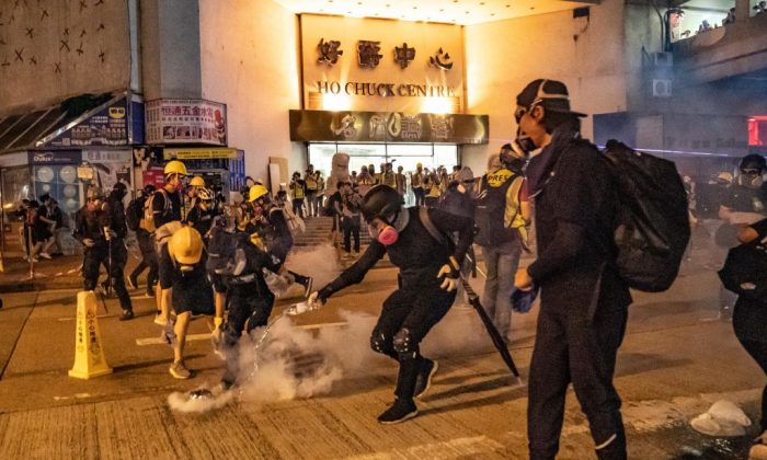 Protesters put out the tear gas as they pour water on it at Kwai Fong district, Hong Kong, on Aug. 11, 2019. (Anthony Kwan/Getty Images)