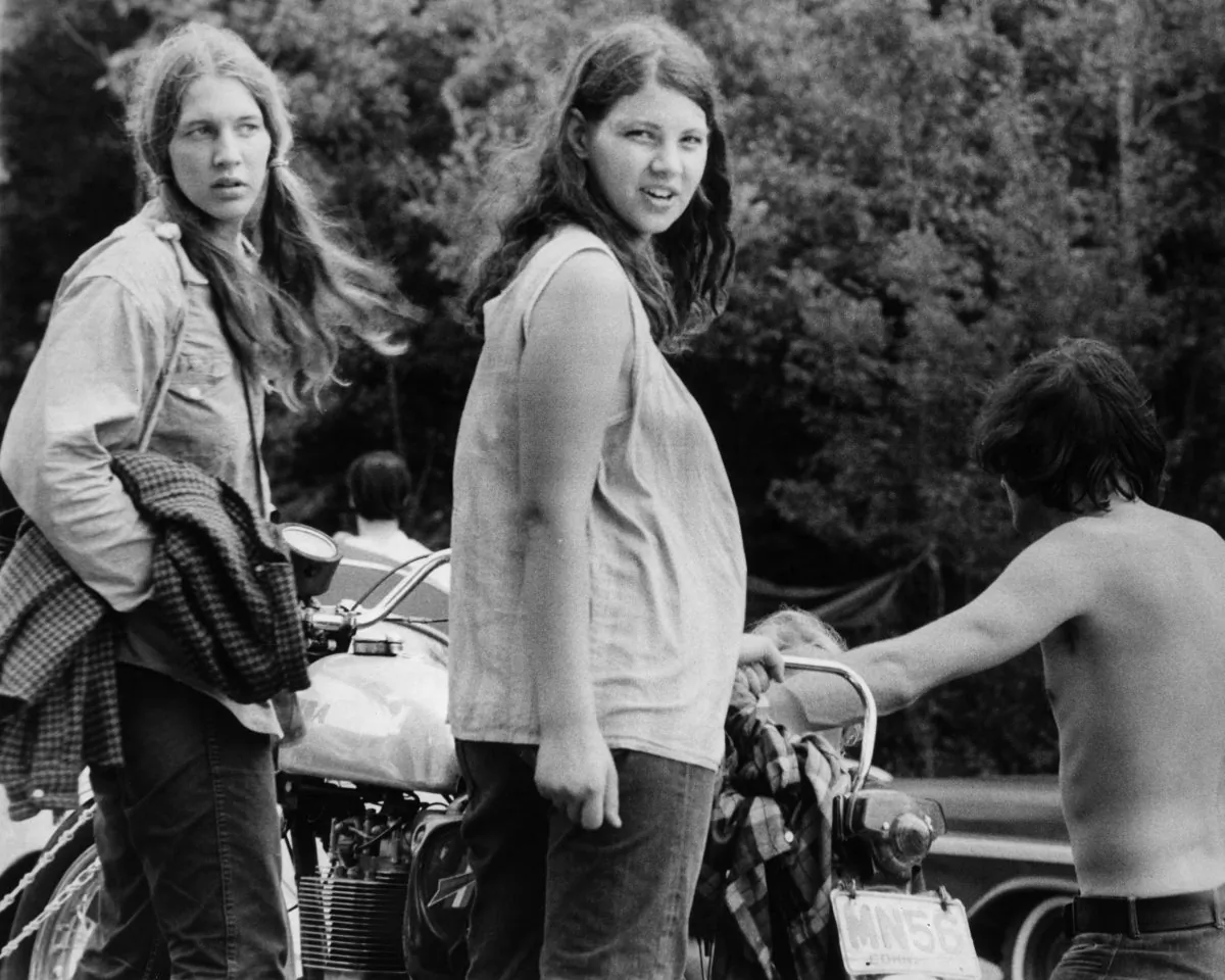 August 1969: A pregnant woman and her friend wait as a motorcycle is unhitched from a car, as they prepare to leave Max Yasgur's Bethil farm and the Woodstock music festival. (Photo by Three Lions/Getty Images)