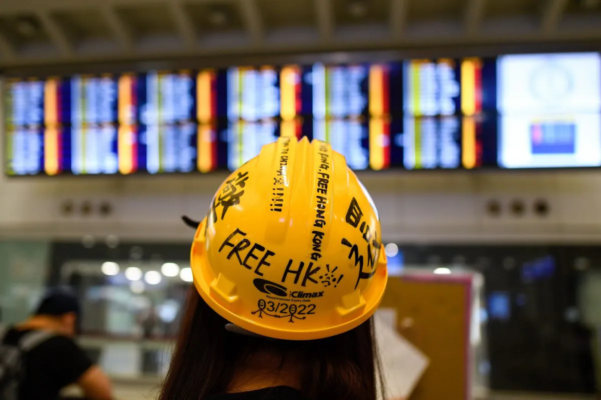 A Pro-Democracy protester looks at the flight information board showing cancelled flights following a protest against police brutality and the controversial extradition bill at Hong Kong's international airport on Aug. 12, 2019. (Manan Vatsyayana/AFP/Getty Images)
