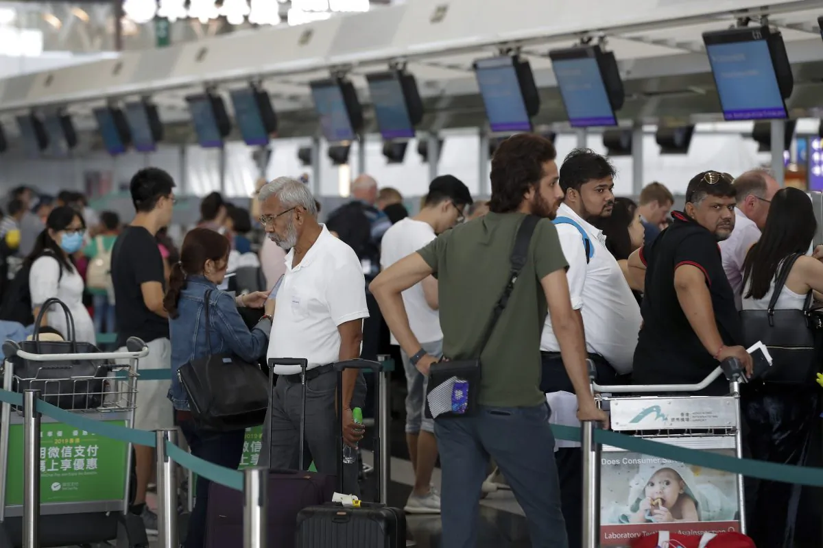 Travelers wait to check in for their flights at the airport in Hong Kong on Aug. 14, 2019. (Vincent Thian/AP Photo)
