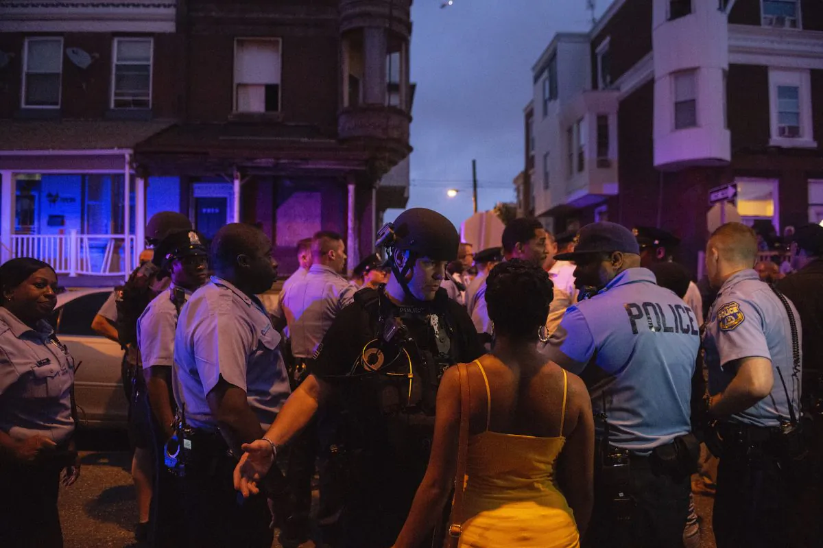 Police officers gather for crowd control during a shooting investigation in Philadelphia on Wednesday, Aug. 14, 2019. (Joe Lamberti/Camden Courier-Post via AP)