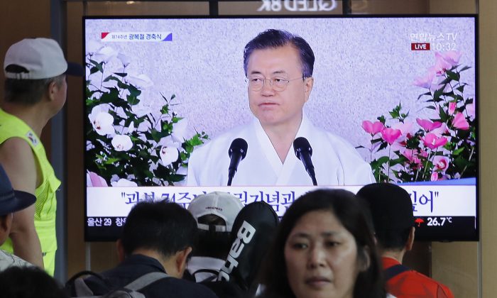 People watch a TV screen showing a live broadcast of South Korean President Moon Jae-in's speech during a ceremony to celebrate the Korean Liberation Day, marking the 74th anniversary of Korea's liberation from the Japanese colonial rule, at the Seoul Railway Station in Seoul, South Korea, on Aug. 15, 2019. The signs read: "Korean Liberation Day." (AP Photo/Ahn Young-joon)