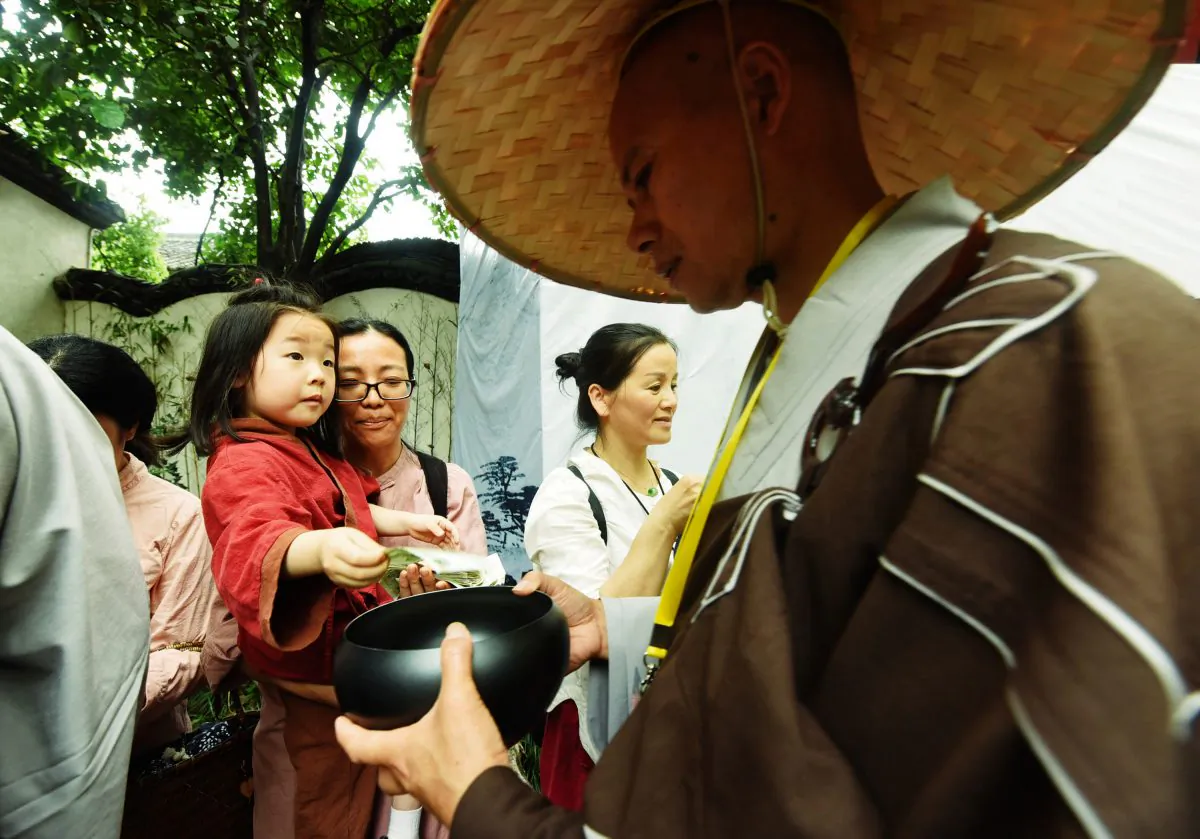 A monk receives donation from a girl during a traditional mendicants' walk in Hangzhou in China's eastern Zhejiang Province on May 22, 2018. Monks walked from Faxi Temple to Lingyin Temple as they received donations from residents for charity, to mark the birthday of Shakyamuni, founder of Buddhism. (AFP/Getty Images)