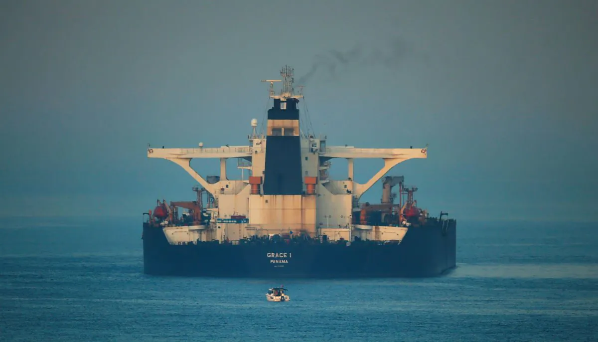 A small boat sails past Iranian oil tanker Grace 1 as it sits anchored after it was seized in July by British Royal Marines off the coast of the British Mediterranean territory on suspicion of violating sanctions against Syria, in the Strait of Gibraltar, southern Spain August 13, 2019. (Reuters/Jon Nazca/File Photo)