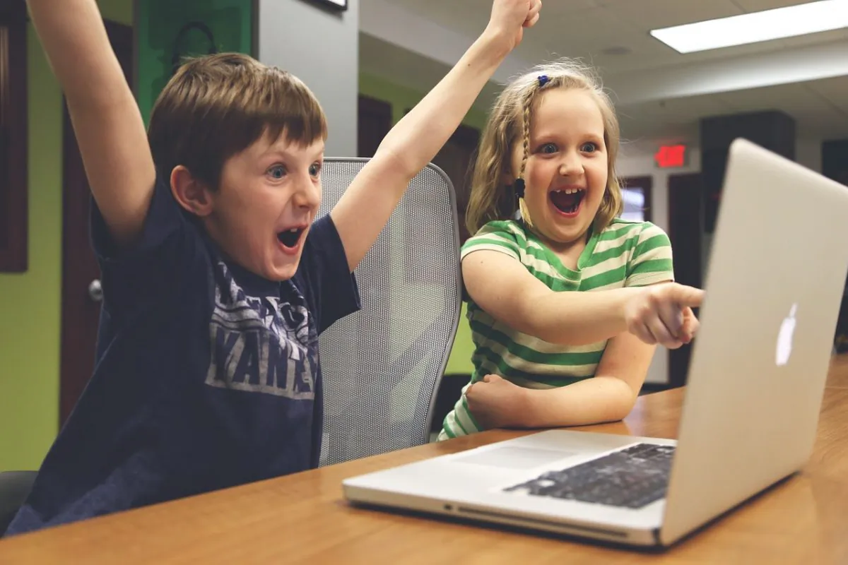 Boy and girl looking at laptop. (Pixabay)