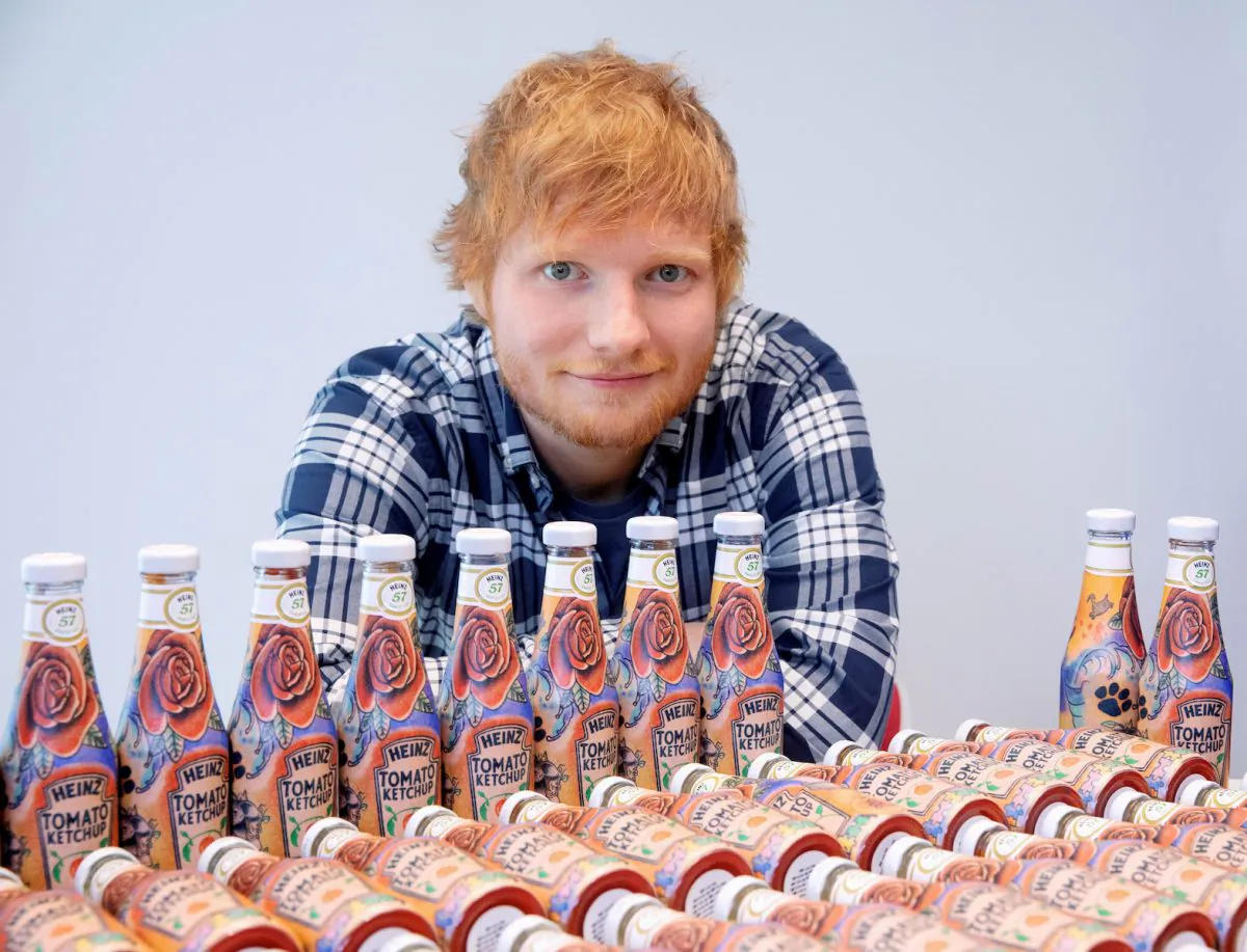 Ed Sheeran poses with bottles of Heinz Tomato Ketchup based on his tattoos in London, Britain May 20, 2019, in this handout photo. (Heinz/Handout via Reuters)