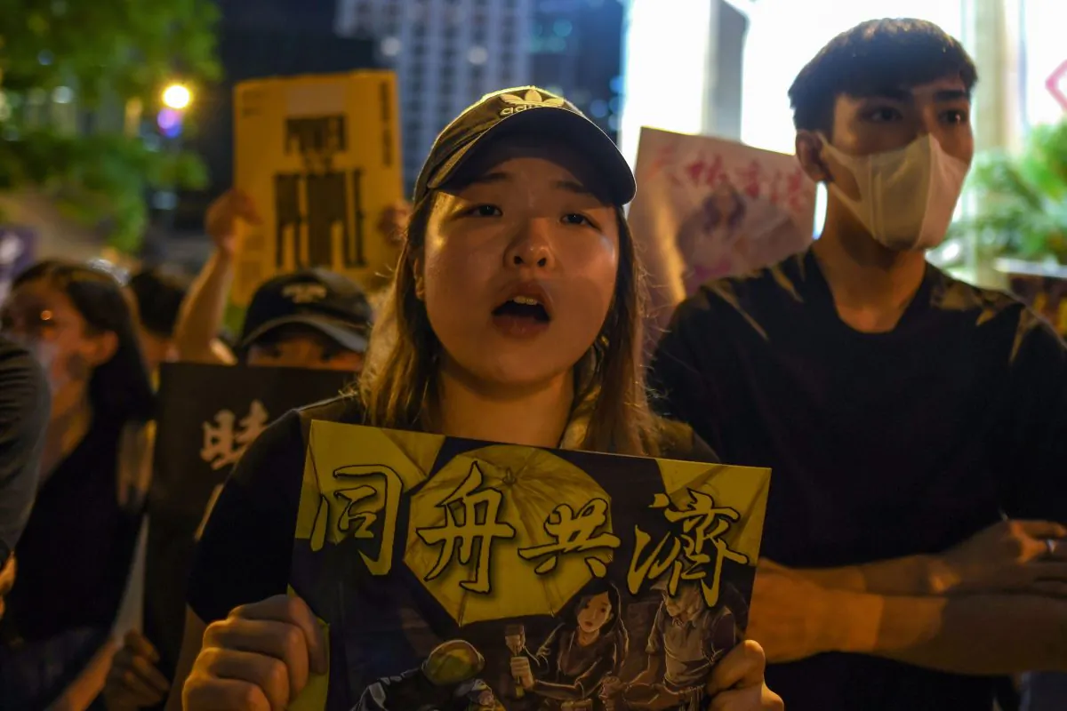 Pro-democracy protesters hold signs as they attend a rally in Hong Kong on Aug. 16, 2019. (Manan Vatsyayana/AFP/Getty Images)