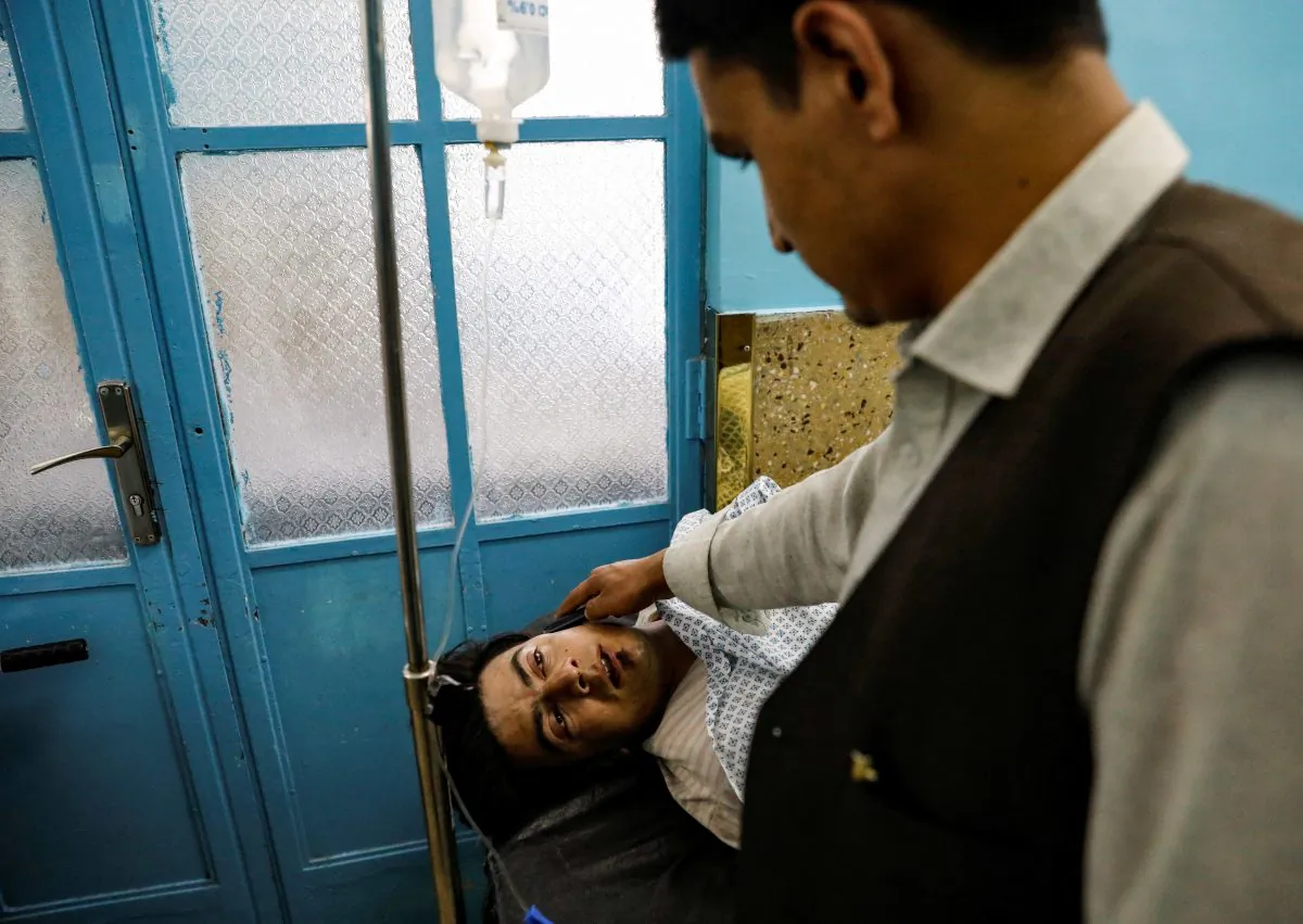 An injured man talks on a mobile phone while receiving treatment in the hospital after sustaining wounds from a blast at a wedding hall in Kabul, Afghanistan, on Aug. 18, 2019. (REUTERS/Mohammad Ismail)