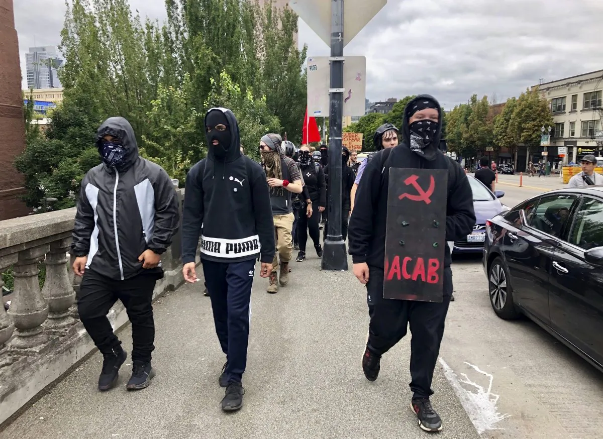 Antifa members cross Burnside Bridge from the west side of the city to the east side in search of conservative ralliers in Portland, Oregon, on Aug. 17, 2019. (AP Photo/Gillian Flaccus)