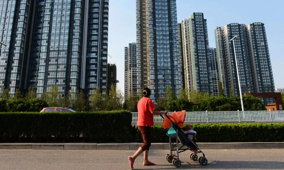 A woman walking a baby along the street in China in this file photo. (STR/AFP/Getty Images)