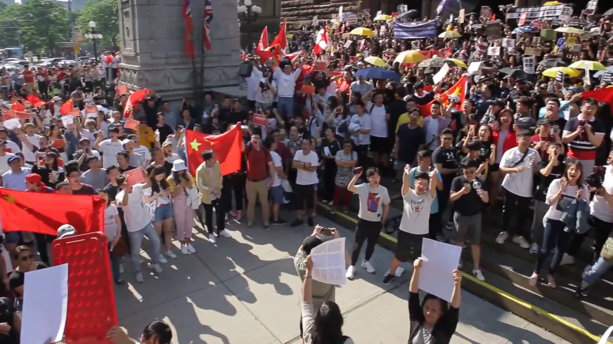 A pro-Beijing group carrying the five-starred red flag blocks Hong Kong supporters from marching at a rally in downtown Toronto on Aug. 17, 2019. (Arek Rusek/NTD Television)