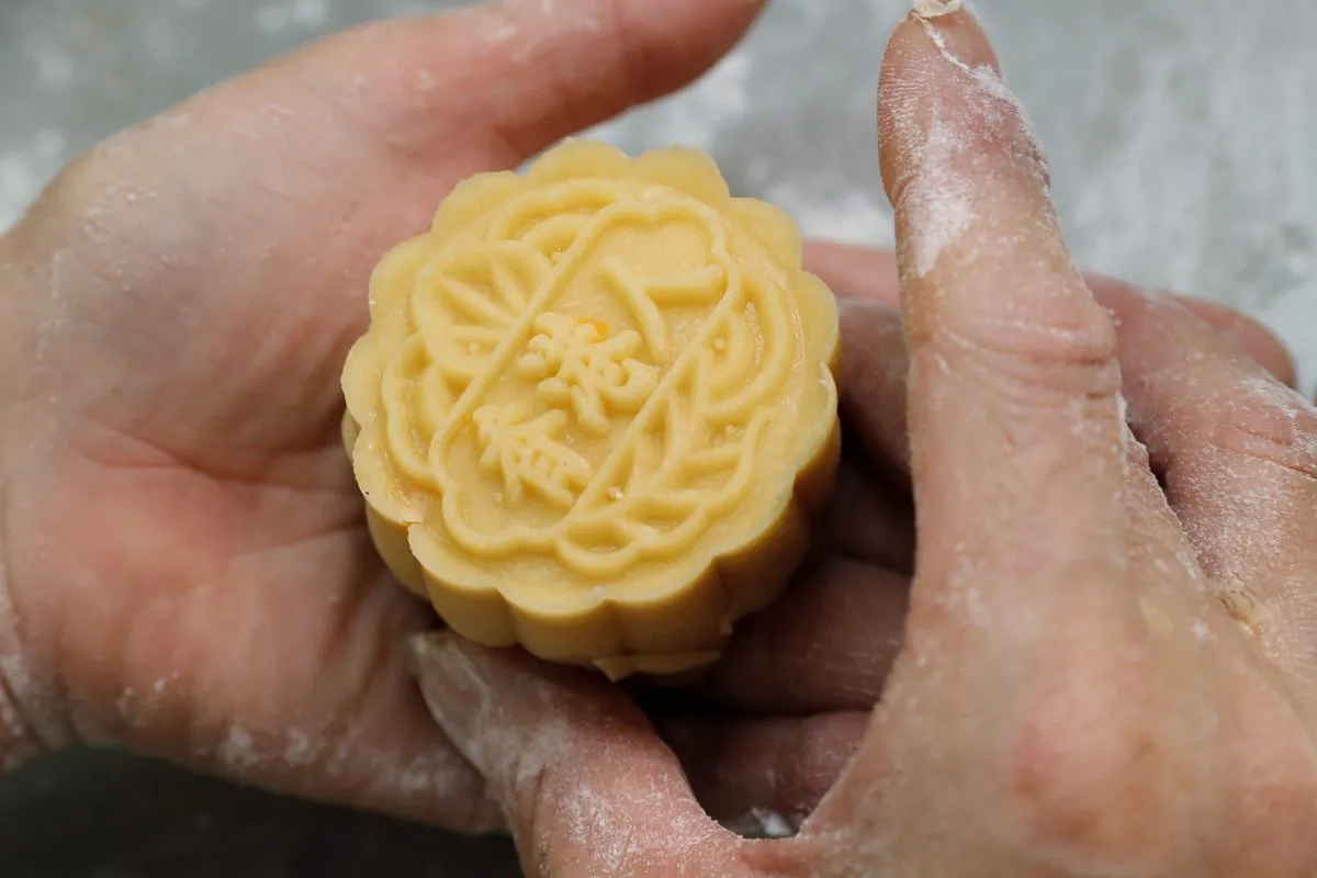 A staff member makes a mooncake with Chinese words "Hong Kong people" at Wah Yee Tang bakery in Hong Kong, China on Aug. 9, 2019. A Hong Kong bakery is doing its part to support the city’s pro-democracy protest movement by making mooncakes with a message. (Kin Cheung/AP)
