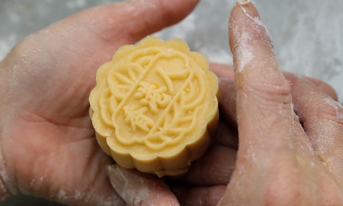 A staff member makes a mooncake with Chinese words "Hong Kong people" at Wah Yee Tang bakery in Hong Kong, China on Aug. 9, 2019. A Hong Kong bakery is doing its part to support the city’s pro-democracy protest movement by making mooncakes with a message. (Kin Cheung/AP)