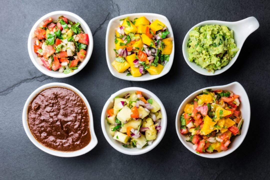 Traditional famous Mexican sauces to try: chocolate chili mole poblano, pico de gallo, avocado guacamole, salsa bandera, pinapple salsa, and mango salsa. (Larisa Blinova/Shuttertock)