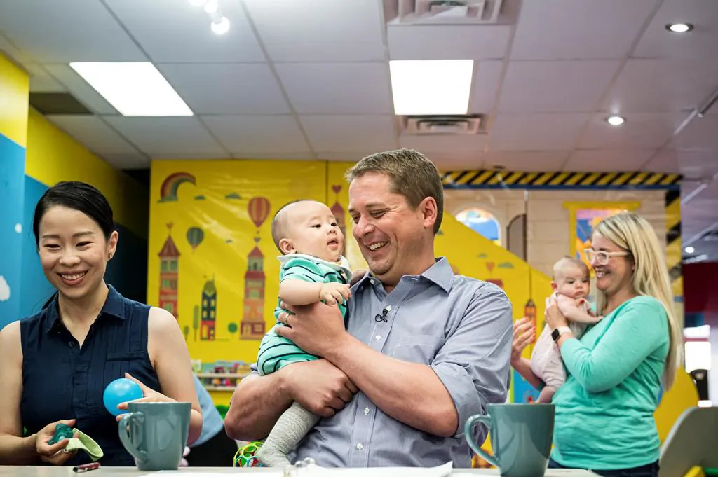 Federal Conservative leader Andrew Sheer holds 4-month old Antonio Wang while caregiver Anna Yang watches at a child care facility where he gave an announcement, on August 20, 2019. (Christopher Katsarov/The Canadian Press)