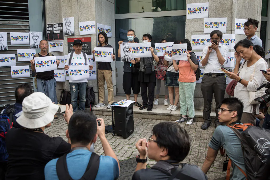 People hold a portrait of British consulate worker Simon Cheng, during a gathering to petition the British government to assist in his release, outside the British Consulate in Hong Kong on Aug. 21, 2019. (Chris McGrath/Getty Images)