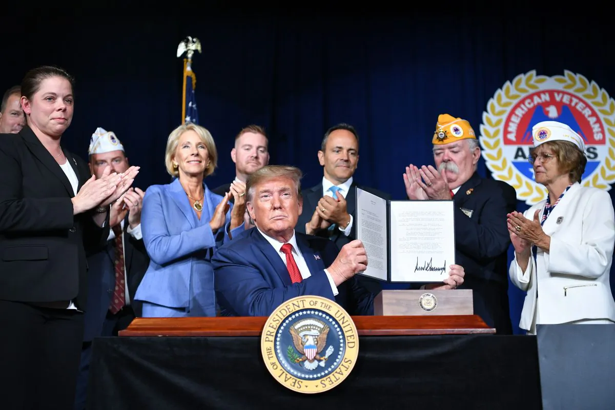 President Donald Trump sign a Presidential Memorandum on Discharging the Federal Student Loan Debt of Totally and Permanently Disabled Veterans, at the American Veterans 75th National Convention in Louisville, Kentucky, on Aug. 21, 2019. (MANDEL NGAN/AFP/Getty Images)