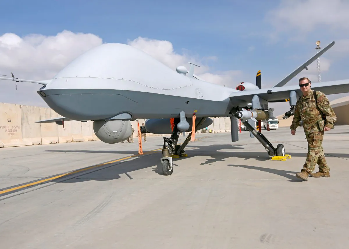A U.S. Air Force officer passes in front of a MQ-9 Reaper drone, one of a squadron that has arrived to step up the fight against the Taliban, at the Kandahar air base, Afghanistan on Jan. 23, 2018. (Omar Sobhani/Reuters)