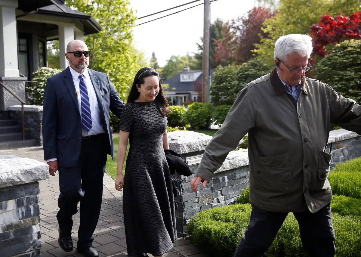 Huawei's Financial Chief Meng Wanzhou leaves her family home flanked by private security in Vancouver, British Columbia, Canada on May 8, 2019. (Lindsey Wasson/Reuters)