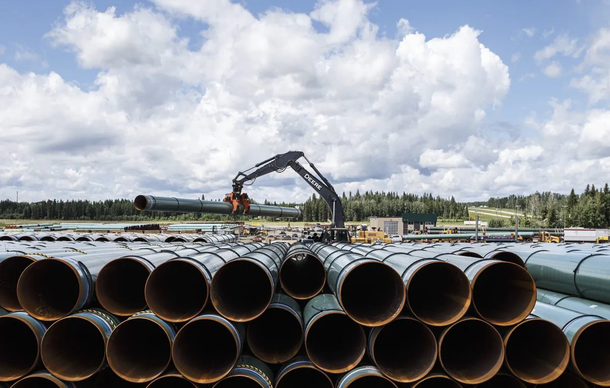 Pipe for the Trans Mountain project is unloaded in Edson, Alta. on June 18, 2019. (Jason Franson/The Canadian Press)