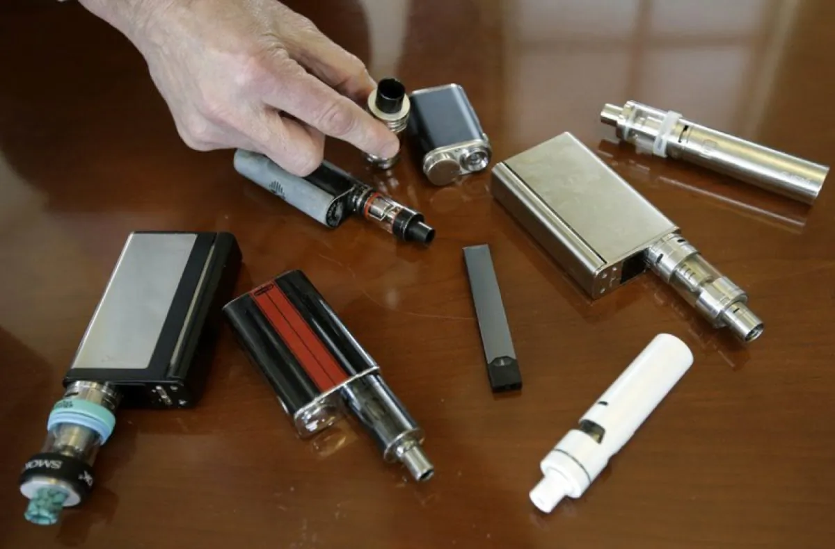 Robert Keuther, a high school principal in Marshfield, Mass., displays vaping devices confiscated from students in restrooms or hallways at the school. (Steven Senne/AP Photo)