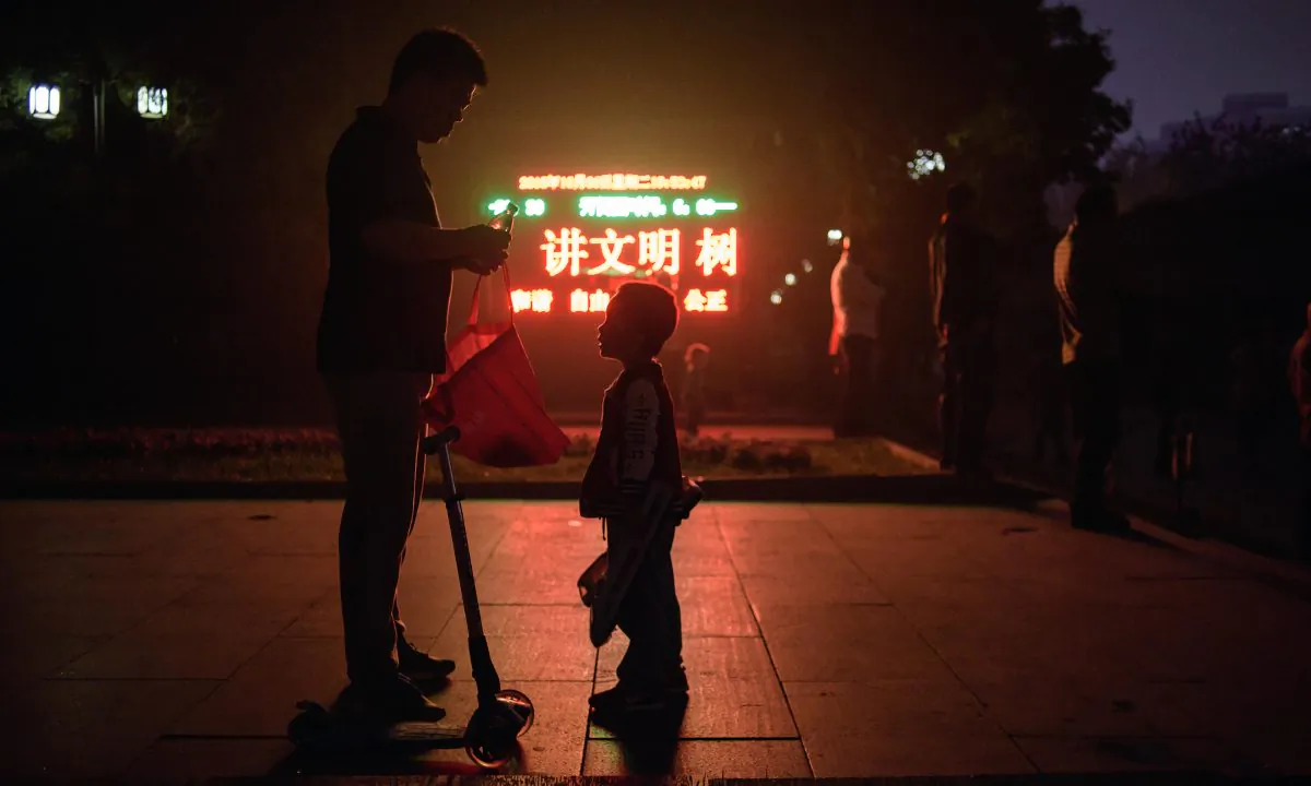A father and son out at night in China in this file photo. (Ed Jones/AFP/Getty Images)
