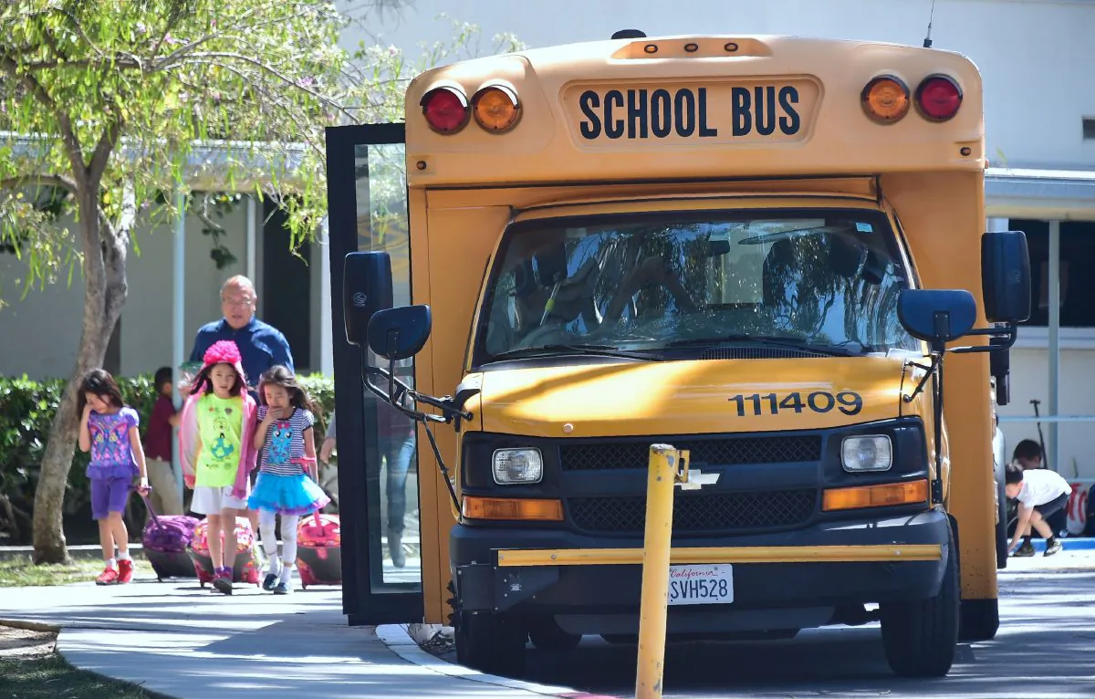Children walk past a school bus in Monterey Park, Calif., on April 28, 2017. (Frederic J. Brown/AFP/Getty Images)