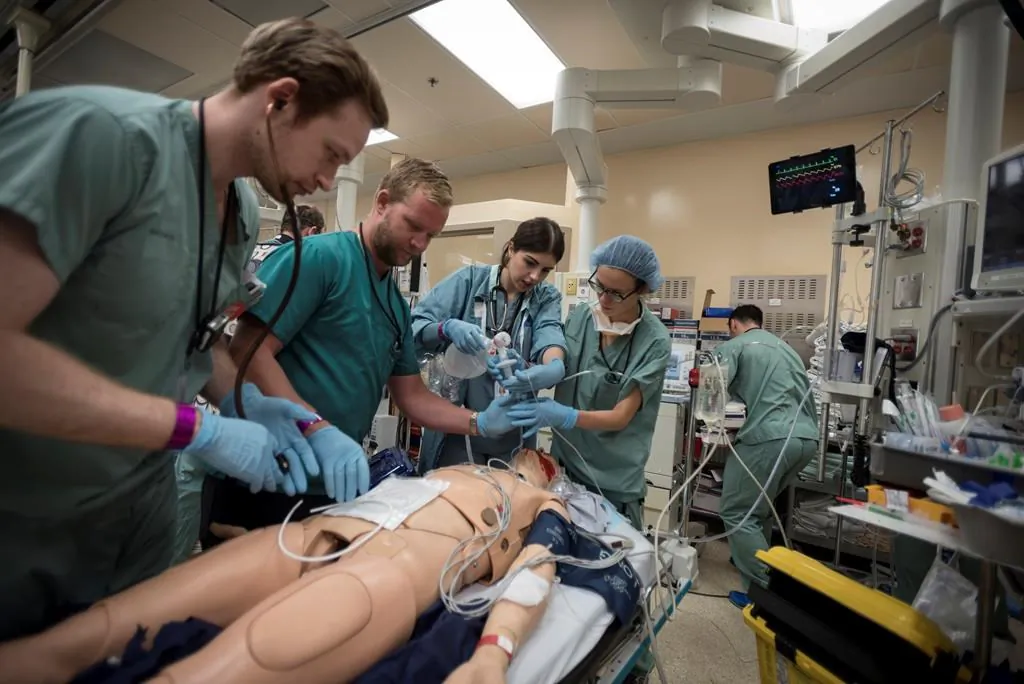Dr. Christopher Tsoutsoulas (left to right), Dr. Craig Brick, Diana Kanlic and Dr. Clare Toguri, tend to a medical mannequin in the trauma bay during a mass casualty simulation at St. Michael's Hospital in Toronto on August 13, 2019. (Tijana Martin/The Canadian Press)