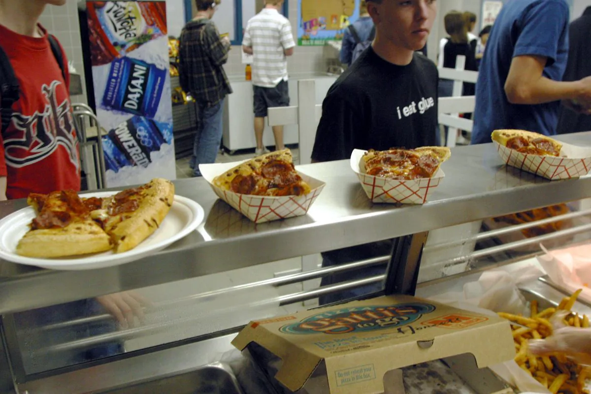 Students line up to receive food during lunch in the cafeteria at Bowie High School  in Austin, Texas on March 11, 2004. The Austin School District is working to make their cafeteria offerings more healthy, but the most  popular foods are still fried chicken strips, pizza, and french fries. Concern about increased levels of childhood obesity in the United States has made the food served in public schools cafeterias a much greater concern. (Jana Birchum/Getty Images)
