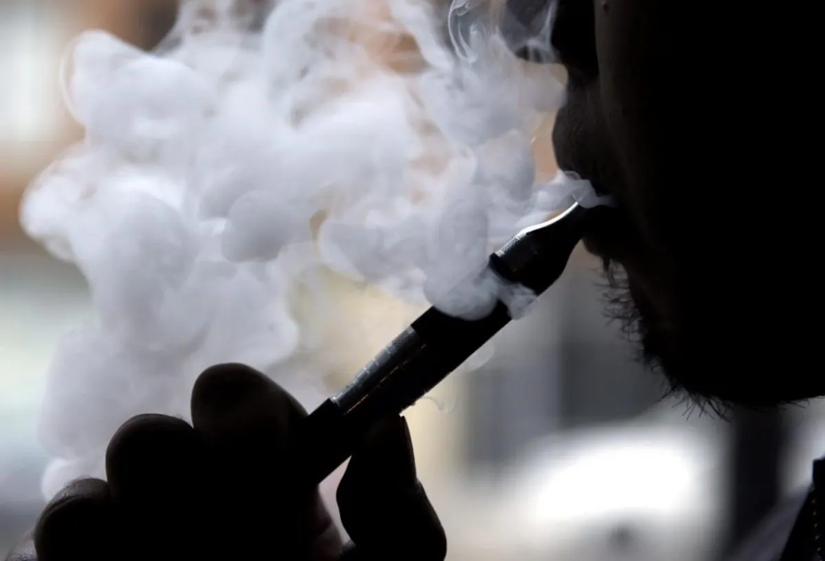 A man smokes an electronic cigarette in Chicago on April 23, 2014. THE CANADIAN PRESS/AP/Nam Y. Huh, File