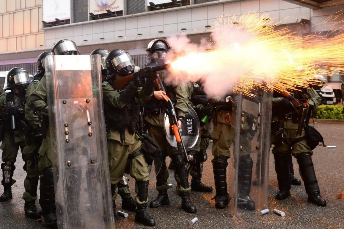 A Hong Kong policeman is shooting tear gas on Yeung Uk road of Tsuen Wan on the evening of Aug. 25, 2019. (Song Bilong/The Epoch Times)