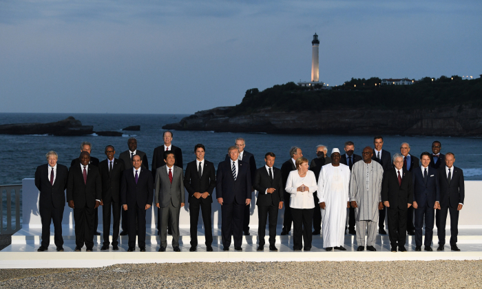G-7 leaders and guests pose for a family picture with the Biarritz lighthouse in the background on the second day of the annual G-7 summit: (First row) L-R Britain's Prime Minister Boris Johnson, South Africa's President Cyril Ramaphosa, Rwanda's President Paul Kagame, African Union Chair Egyptian President Abdel Fattah el-Sisi, Japan's Prime Minister Shinzo Abe, Canada's Prime Minister Justin Trudeau, US President Donald Trump, France's President Emmanuel Macron, Germany's Chancellor Angela Merkel, Senegal's President Macky Sall, Burkina Faso's President Roch Marc Christian Kabore, Chile's President Sebastian Pinera, Italy's Prime Minister Giuseppe Conte, European Council President Donald Tusk; (Second row) Chairperson of the African Union Commission Moussa Faki Mahamat (2nd,L), Australian Prime Minister Scott Morrison (4th,L), United Nations Secretary-General Antonio Guterres (6th,R), India's Prime Minister Narendra Modi (5th,R), Spain's Prime Minister Pedro Sanchez (3rd,R), OECD Secretary-General Jose Angel Gurria (2nd,R), African Development Bank president Akinwumi Adesina (R) in Biarritz, France, on Aug. 25, 2019. (Andrew Parsons/Getty Images)