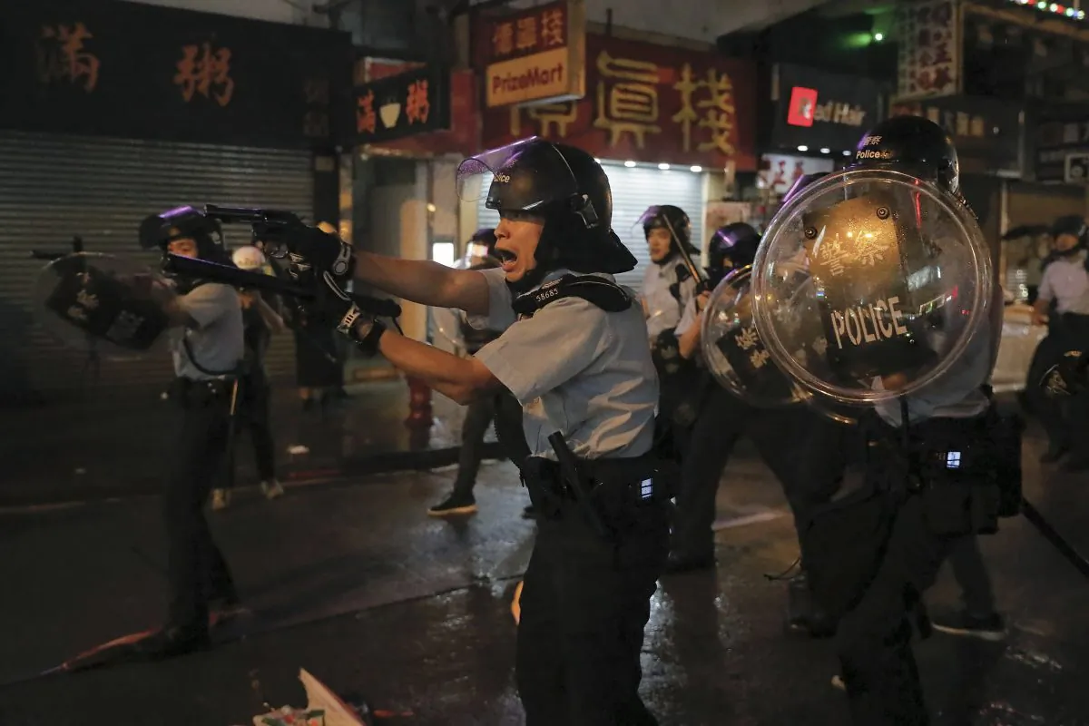 Policemen pull out their guns after a confrontation with demonstrators during a protest in Hong Kong, on Aug. 25, 2019. (AP Photo/Vincent Yu)