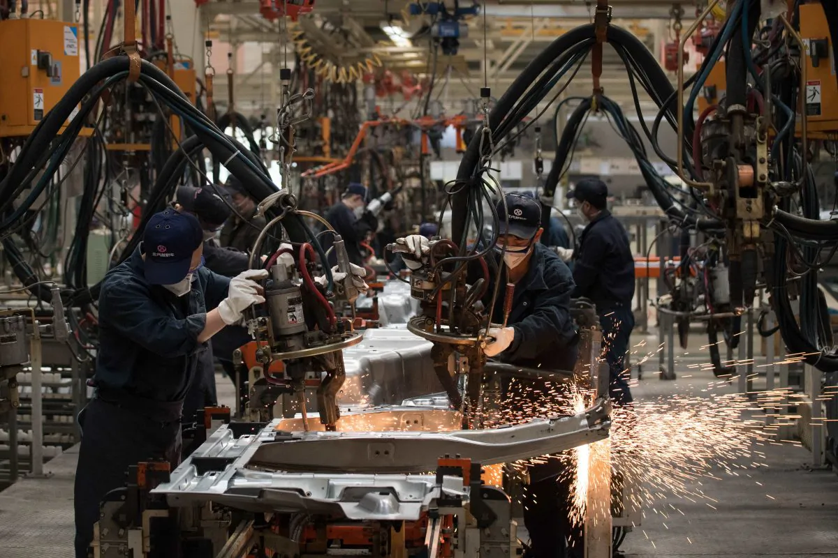 Workers weld SUV parts at the BAIC (Beijing Automotive Group Co) SUV assembly line in Beijing on August 29, 2018. NICOLAS ASFOURI/AFP/Getty Images