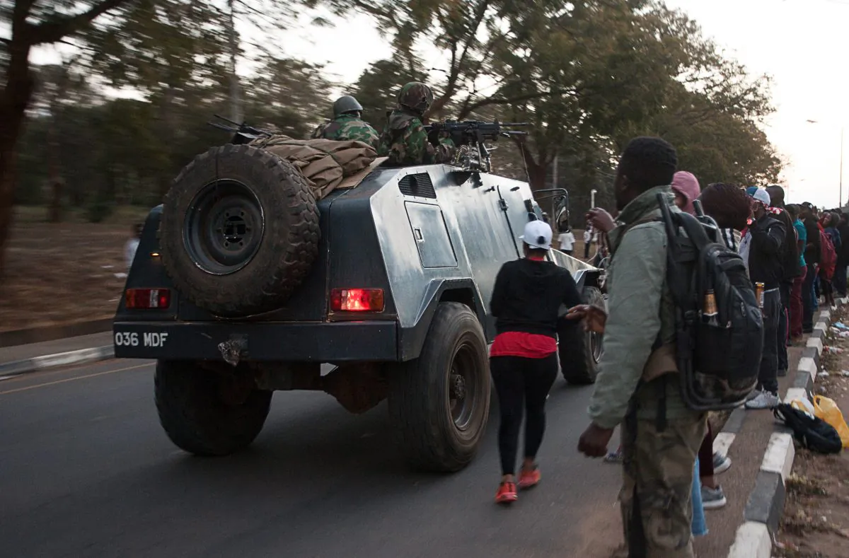 Protesters watch a Malawi Defense Force armored vehicle passing by during an overnight vigil against the result of the May 21 presidential vote in Lilongwe, Malawi, on July 4, 2019. (Amos Gumulira/AFP/Getty Images)